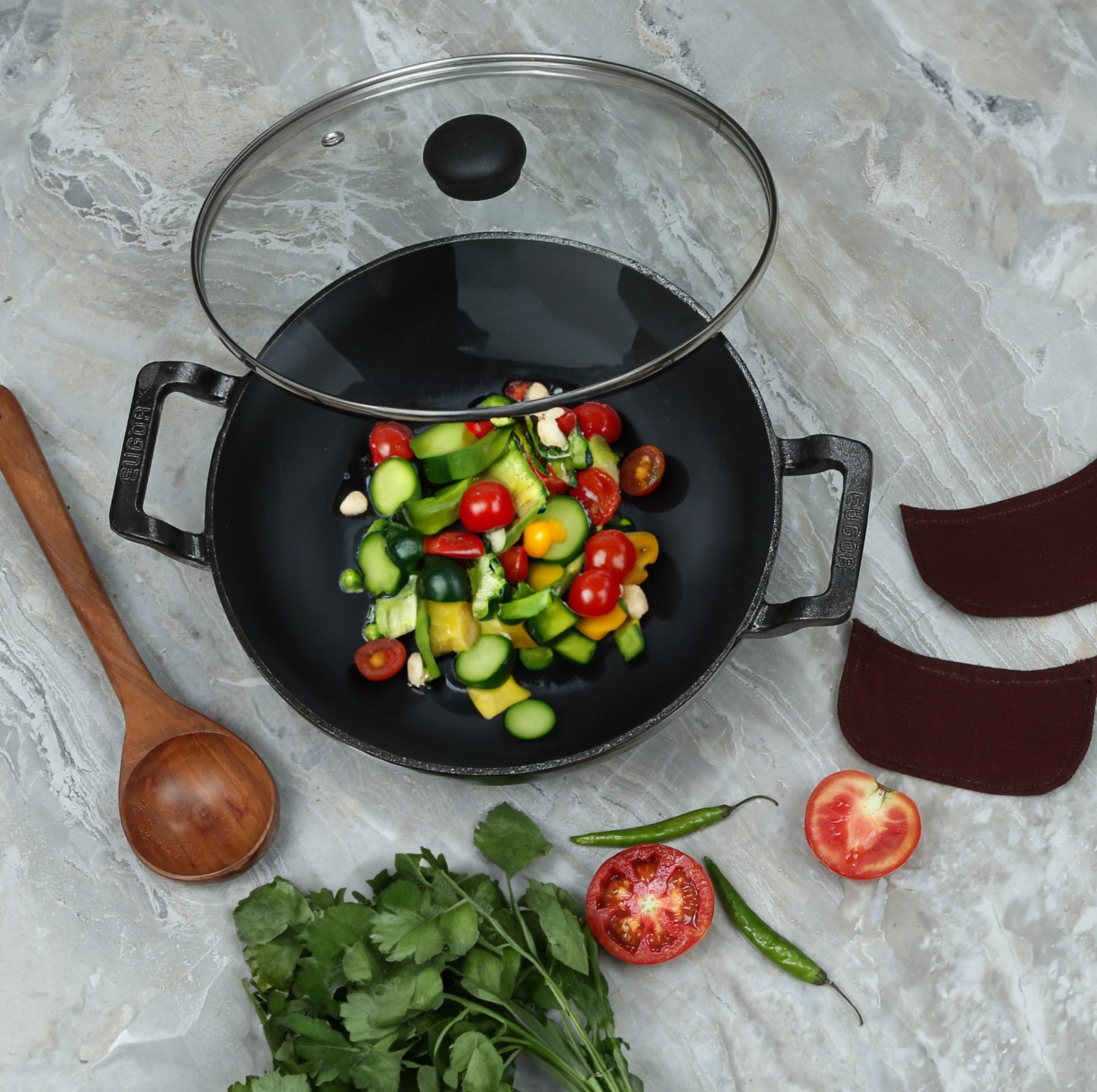 A black cast iron wok filled with colorful chopped vegetables